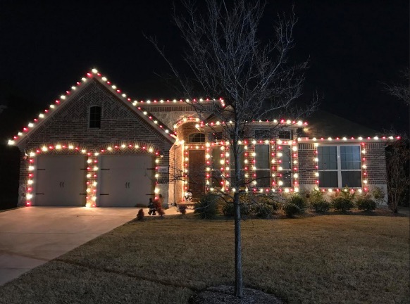 Single-story brick home outlined in red and white C9 bulbs